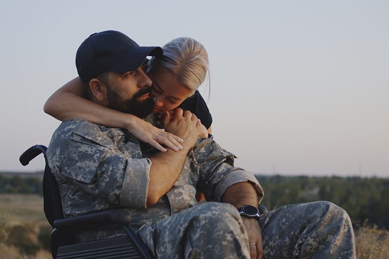 solider in wheelchair hugging woman
