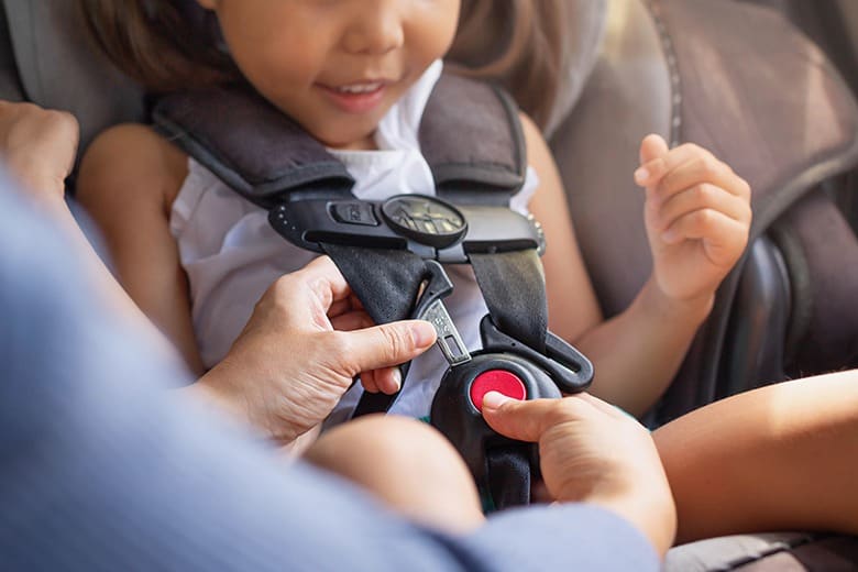 parent putting child into car seat