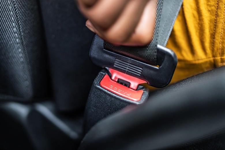 person buckling seatbelt