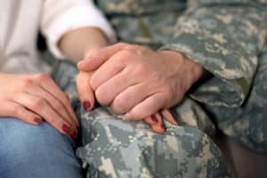 soldier and woman holding hands