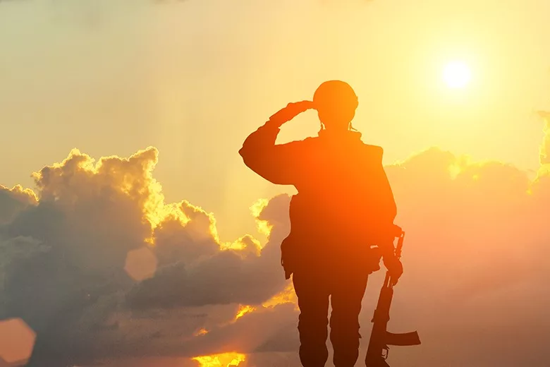 veteran saluting at sunset
