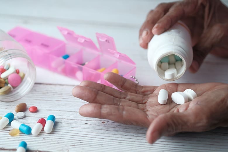 person pouring pills into hand