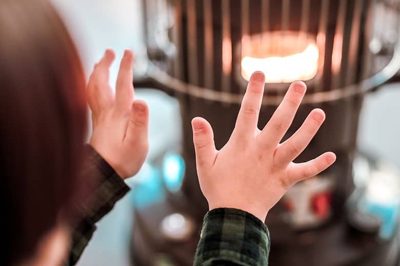 child-warming-hands-by-kerosene-heater