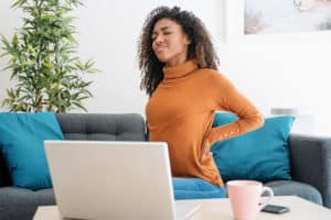 woman-with-back-pain-hand-on-back-working-from-home