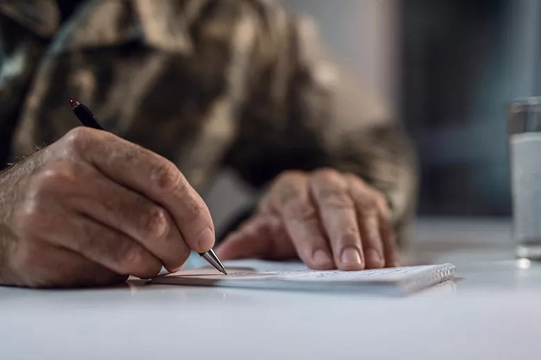 veteran-soldier-in-uniforming-filling-out-paperwork