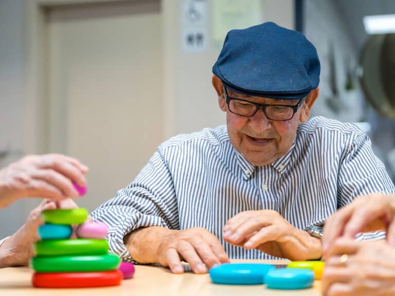 older man playing a game at an adult daycare facility